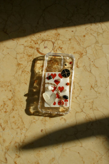 A cell phone case with hearts and buttons on it