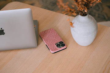 Laptop, phone, and vase on a wooden desk